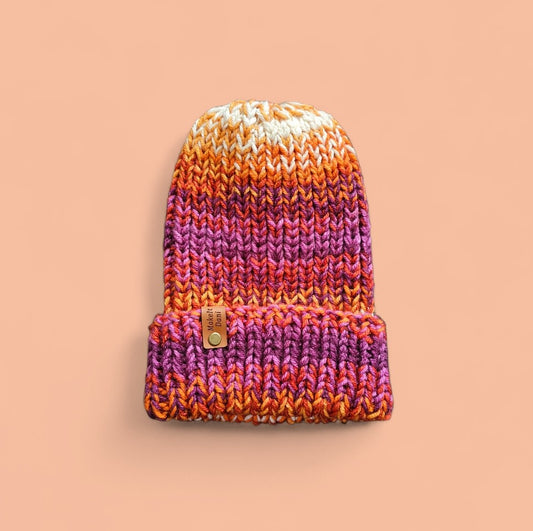 Knitted beanie with gradient colors on a beige background